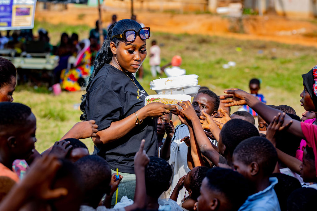 Image of a lady feeding a bunch of children